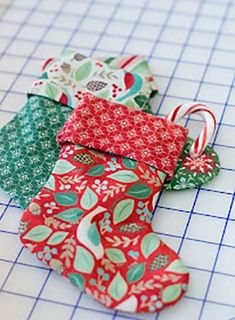 four small christmas stockings are sitting on a cutting board