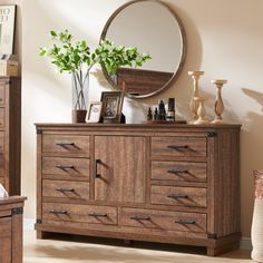 a dresser with drawers, mirror and vase on it in a living room or bedroom