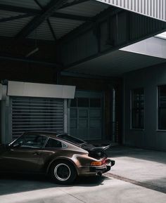 a brown porsche parked in front of a garage