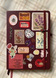 a red notebook covered in stickers and magnets