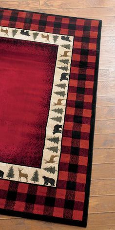 a red and black area rug on the floor with an animal border in the center