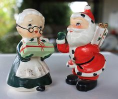 two ceramic figurines sitting on top of a table