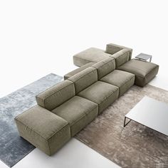 a large sectional couch sitting on top of a rug next to a table and chair