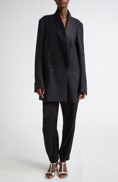 Van Noten's unique take on the tuxedo jacket means an oversized cut that draws attention to what makes it the pinnacle of formalwear, such as the balance struck between matte and sheen via satin covering the buttons, pocket openings and smoothly curved lapels. This style was represented in the Belgian designer's fall '24 runway show. 36" length (size Small) Double-breasted button closure Shawl collar Four-button cuffs Chest welt pocket; front welt pockets Lined 82% wool, 10% silk, 8% polyester D Chic Semi-formal Tuxedo With Pressed Crease, Tailored Chic Tuxedo For Evening, Chic Tailored Tuxedo For Evening, Tuxedo Blazer With Structured Boning, Chic Formal Tuxedo For Fall, Chic Fall Tuxedo For Formal Occasions, Fall Evening Suits With Double Button Closure, Sleek Outerwear With Concealed Placket For Evening, Structured Blazer Dress With Hidden Button For Evening