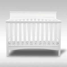 a white crib is shown against a gray background