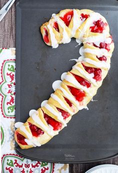 a pastry shaped like the number seven with strawberries and cream in it on a black tray