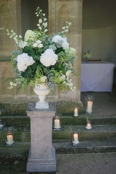 a vase with flowers and candles on some steps