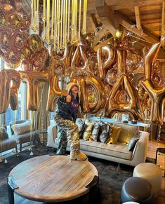 a man is sitting on a couch in front of some balloons and gold foil letters