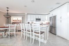 a large kitchen with white cabinets and an island