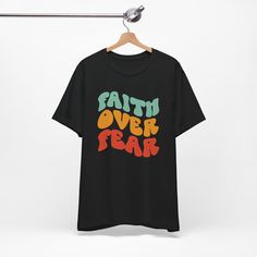 Embrace the power of faith: Uplifting message: "Faith Over Fear" serves as a constant reminder to face any situation with courage, knowing that God is always with you. Declare your faith with confidence: This t-shirt is a subtle yet bold way to express your beliefs and inspire others. Find strength and unwavering trust: Wear this shirt as a source of comfort and a reminder that you are never alone. Perfect for: Everyday wear: Infuse your day with faith as this t-shirt serves as a constant remind Faith And Fear Both Demand, Faith Over Fear Shirt, God's Presence, Unwavering Faith, Never Alone, Church Events, Hoodies Mens, Faith Over Fear, Christian Shirt