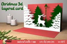 a christmas card with an image of a deer in the woods and a lamp post