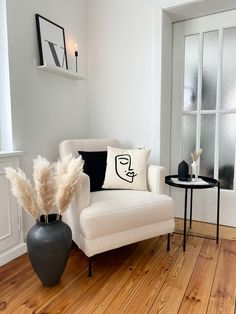 a living room with a couch, chair and side table in front of a window