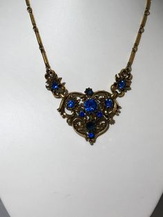 Signed Coro Vintage Antique Necklace SIGNED CORO Blue Rhinestone With Jewelers Brass Gold Tone Chain Jewelry app 16 inch Vintage Antique Necklace SIGNED CORO with Gold Tone Heart and Blue Rhinestones set through out has period 1940's scroll work and is in great condition. Spring Ring clasp. No missing rhinestones, great sparkle and shiny gold tone Jewelers Bronze Base Metal Over all is in excellent condition Shipped first class free 2-5 days Silver Casting, Vintage Rhinestone Necklace, Scroll Work, Antique Necklace, Brass Gold, Chain Jewelry, Blue Rhinestones, Rhinestone Necklace, Vintage Rhinestone