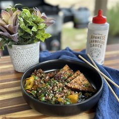 a bowl of food with chopsticks next to it