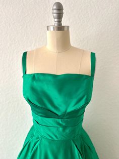 Gorgeous Emerald green vintage 50s  gown/party dress Elegant vintage cocktail dress Pleated Bodice accent with 2 straps/metal zipper in back Measurements: Bust:  32" Waist:  24" Hips:  free Length:  29" (waist to hem) Condition: Excellent pre-loved vintage condition Green 1950s Style Evening Dress, 1950s Style Green Evening Dress, Green Formal Dress In 1950s Style, 50s Gown, Emerald Green Gown, Cocktail Dress Vintage, Green Gown, Dress Pleated, Pleated Bodice