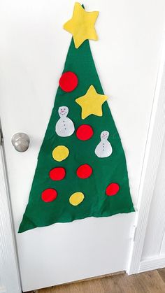 a christmas tree made out of construction paper on the front door, with yellow stars and green felt