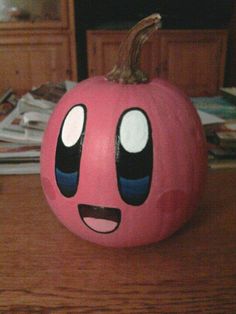 a pink pumpkin with eyes painted on it