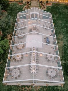 an aerial view of a building with tables and chairs in the center, surrounded by greenery