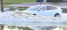 a white car is driving through flood waters