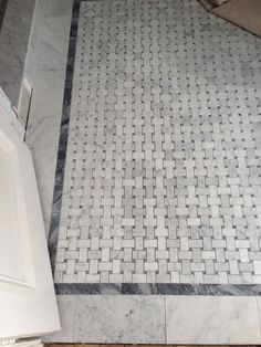 a bathroom with marble flooring and white cabinets