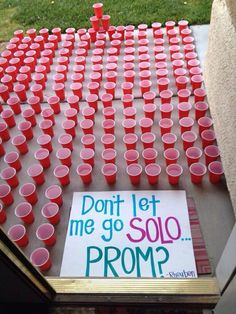 a bunch of red cups sitting on top of a table next to a sign that says don't let me go solo prom