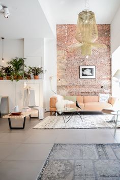 a living room filled with furniture and a brick wall