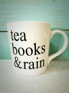 a white coffee cup with the words tea books and rain written on it