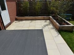 an outdoor patio with raised planters and grass