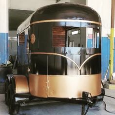 a black and gold trailer parked in a garage