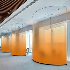 an empty room with orange walls and glass partitions on the wall to divide people from them