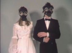 two people wearing gas masks standing next to each other