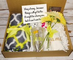 a gift box with flowers, towels and other items in it on a wooden table