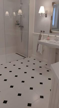 a bathroom with black and white tile flooring next to a walk - in shower