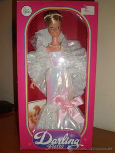 a barbie doll in a pink box with white dress and tiara on it's head