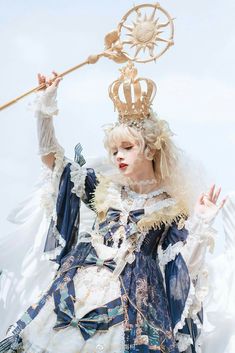 a woman dressed in blue and white holding a wand