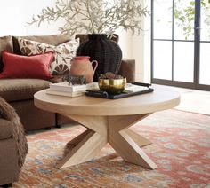 a living room with a couch, coffee table and potted plant on top of it