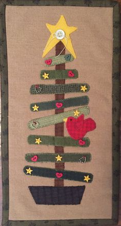 a christmas tree made out of yarn and buttons on a piece of cloth with a star