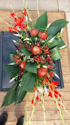 a bouquet of red flowers sitting on top of a wooden floor