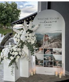 a welcome sign with white flowers and candles