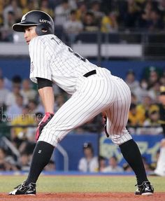 a baseball player standing on top of a field next to home plate in front of an audience