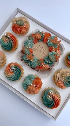 cupcakes with frosting and decorations in a box