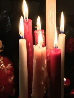 several lit candles are lined up next to each other