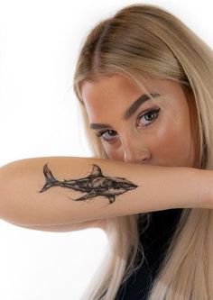 a woman with a shark tattoo on her arm