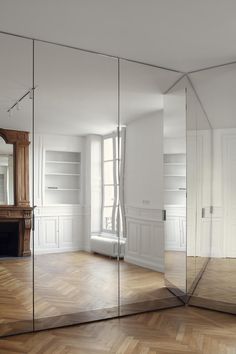 an empty room with mirrored walls and wooden floors