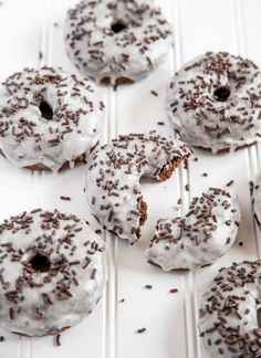 six donuts with white frosting and chocolate sprinkles