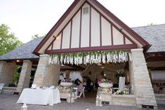 the outside of a building with tables and chairs set up for an outdoor wedding reception