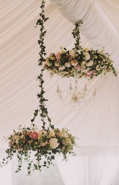 an elegant wedding reception with chandeliers and floral centerpieces hanging from the ceiling