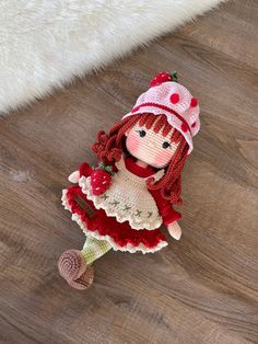 a crocheted doll is sitting on the floor