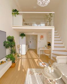 a living room filled with furniture and a flat screen tv sitting on top of a hard wood floor