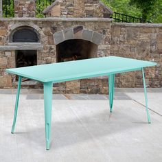 a blue table sitting in front of a brick oven with an open fire place next to it